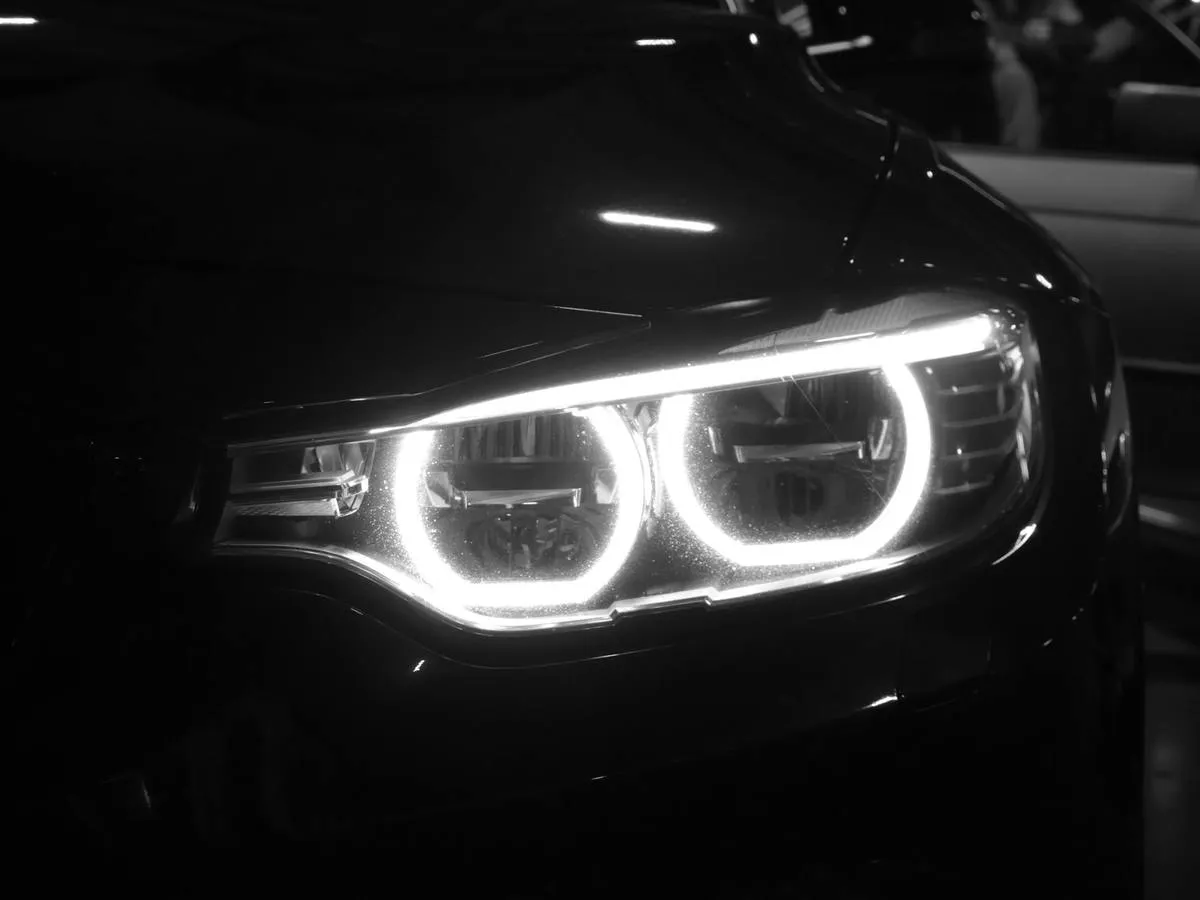 Referência de enquadramento: Farol de carro à noite. O ofuscamento é o problema que essa lente resolve; mostrar o problema comunica melhor que mostrar a lente.